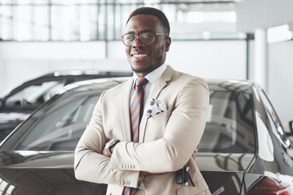 young black businessman on auto salon background car sale and rent concept 1